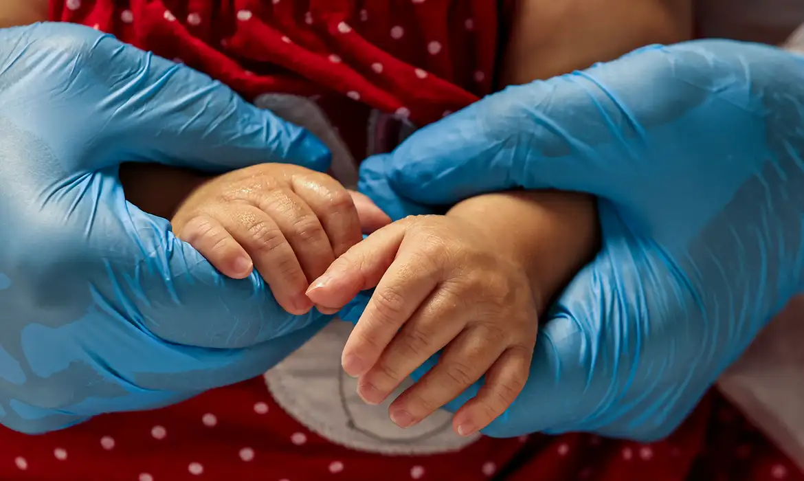 Mãos do médico segurando as mãos da criança