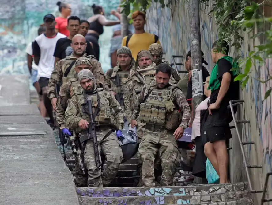 Policiais retiram o corpo de um dos mortos na operação dos Tabajaras
