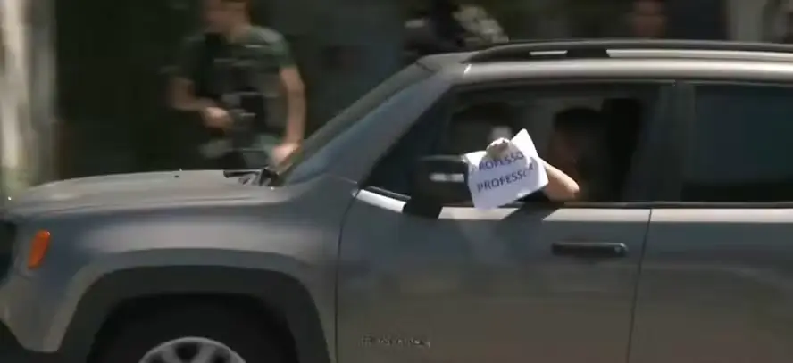'Professor, professor': com medo de ser baleada, mulher passa em meio à operação da polícia com cartaz avisando profissão