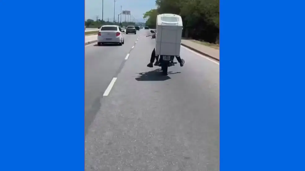 Motociclista carrega máquina de lavar na garupa em Guaratiba