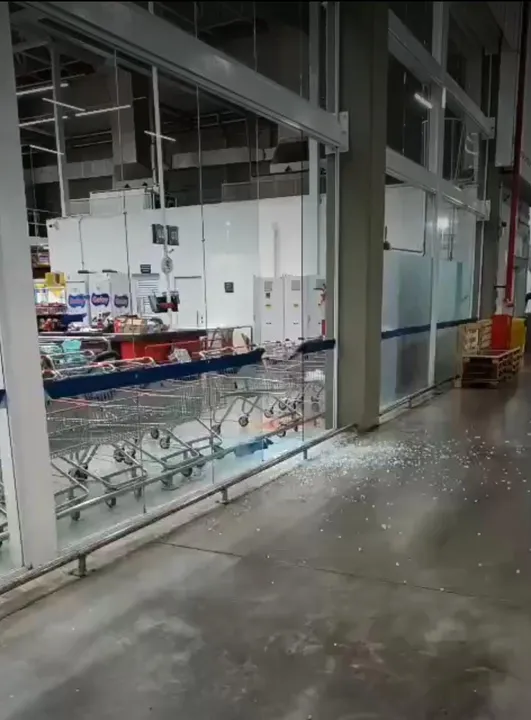 bala perdida atinge supermercado e o vidro de um carro