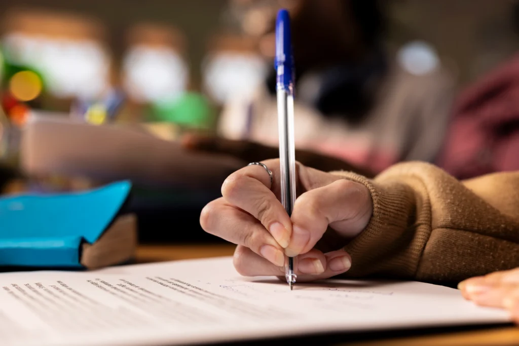 Caneta escrevendo no caderno