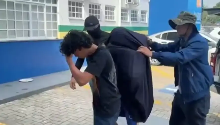 Momento em que os suspeitos chegam à delegacia
