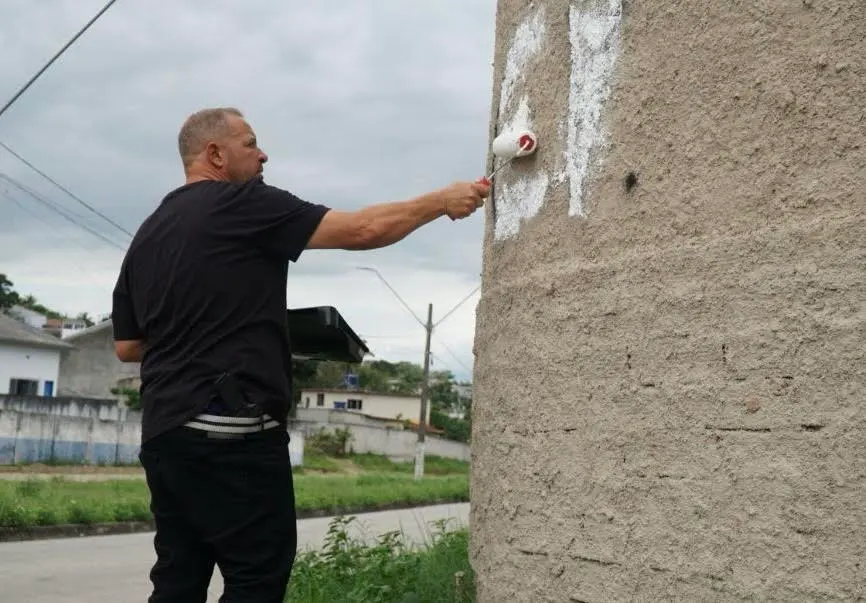 Deputado Guilherme Delaroli apagando com tinta a sigla do Comando Vermelho
