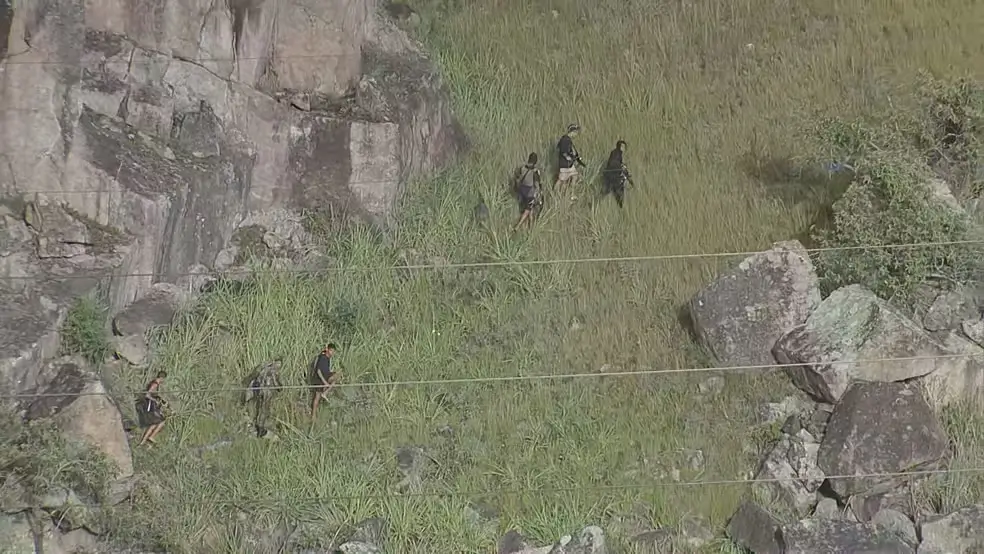 Bandidos armados fogem pela mata durante operação no Morro do Fubá