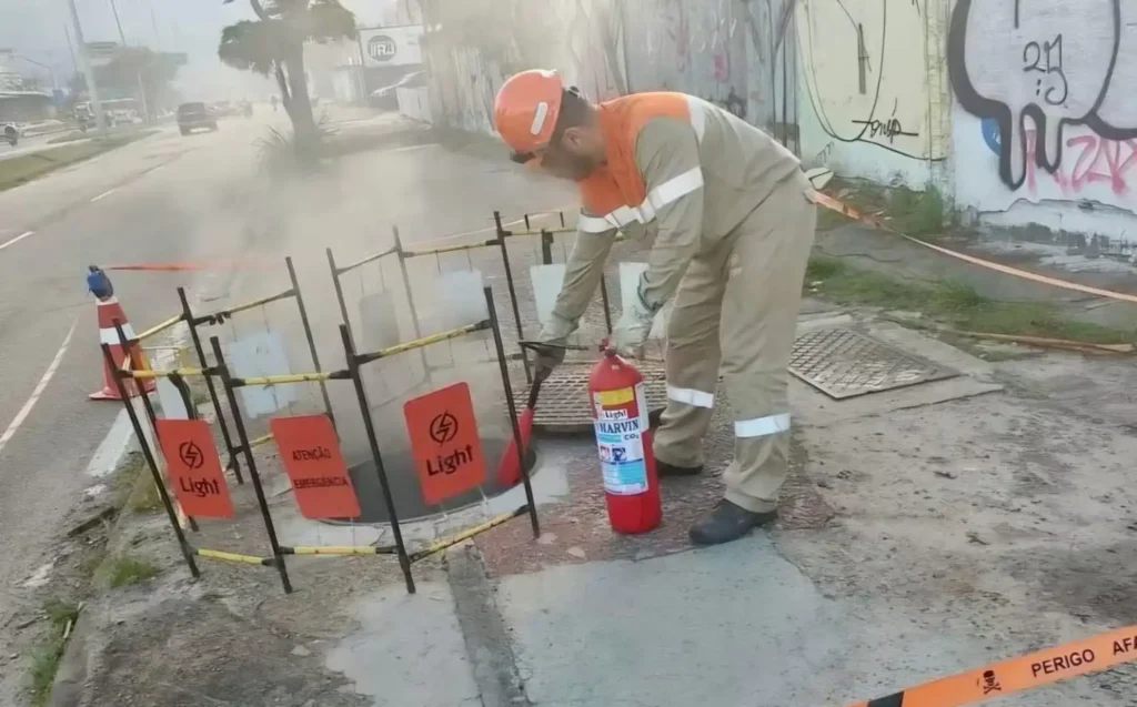Funcionário da Light reparam caixa subterrânea na Avenida das Américas