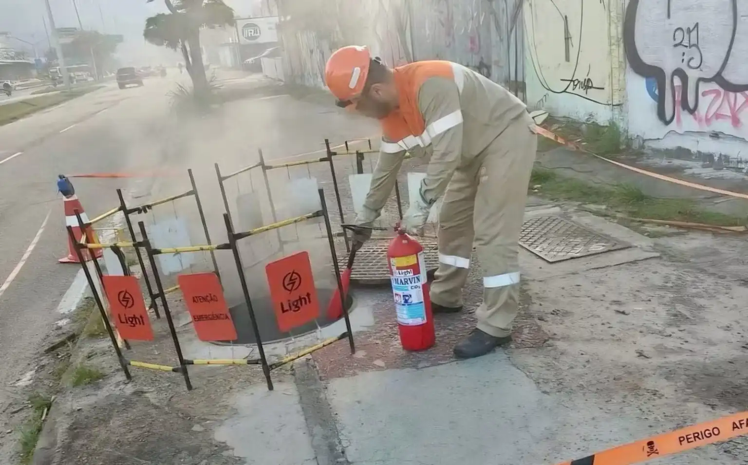 Funcionário da Light reparam caixa subterrânea na Avenida das Américas
