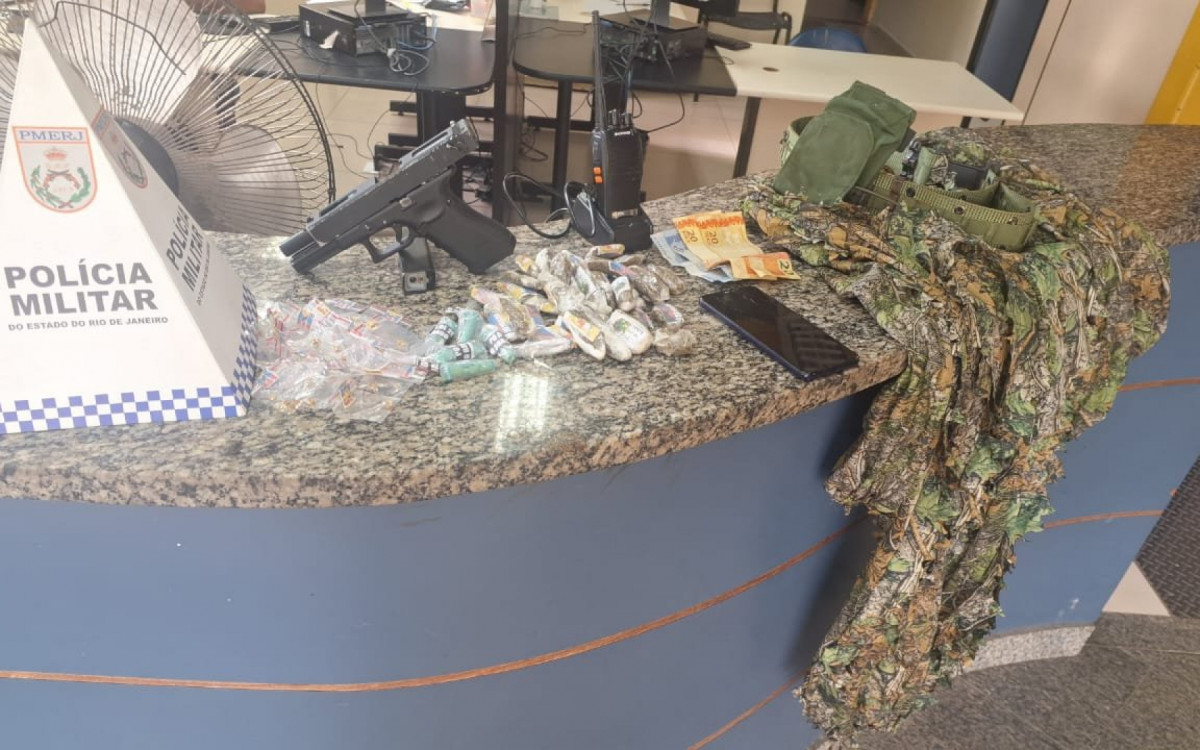 arma falsa e traje camuflado