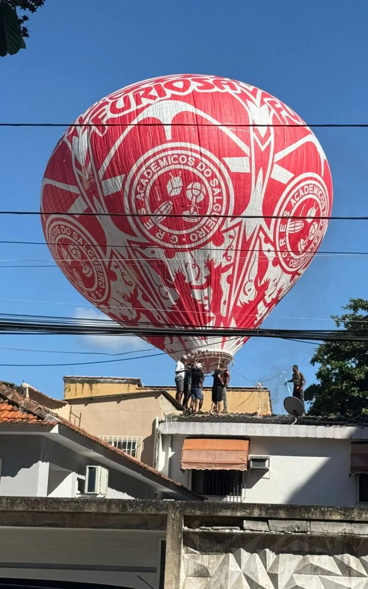 Homens subiram no telhado de uma casa para recuperar balão após queda