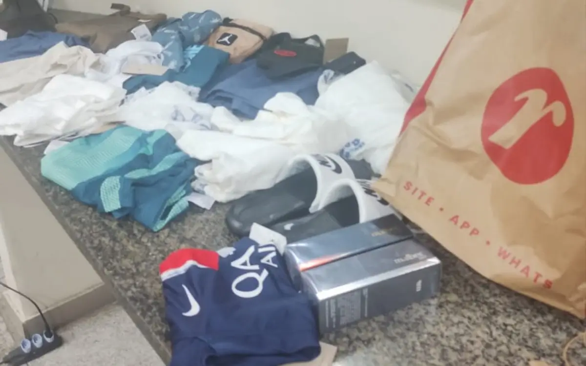 Foram apreendidas 20 peças de roupas, um par de chinelos, duas bolsas e duas caixas de perfume