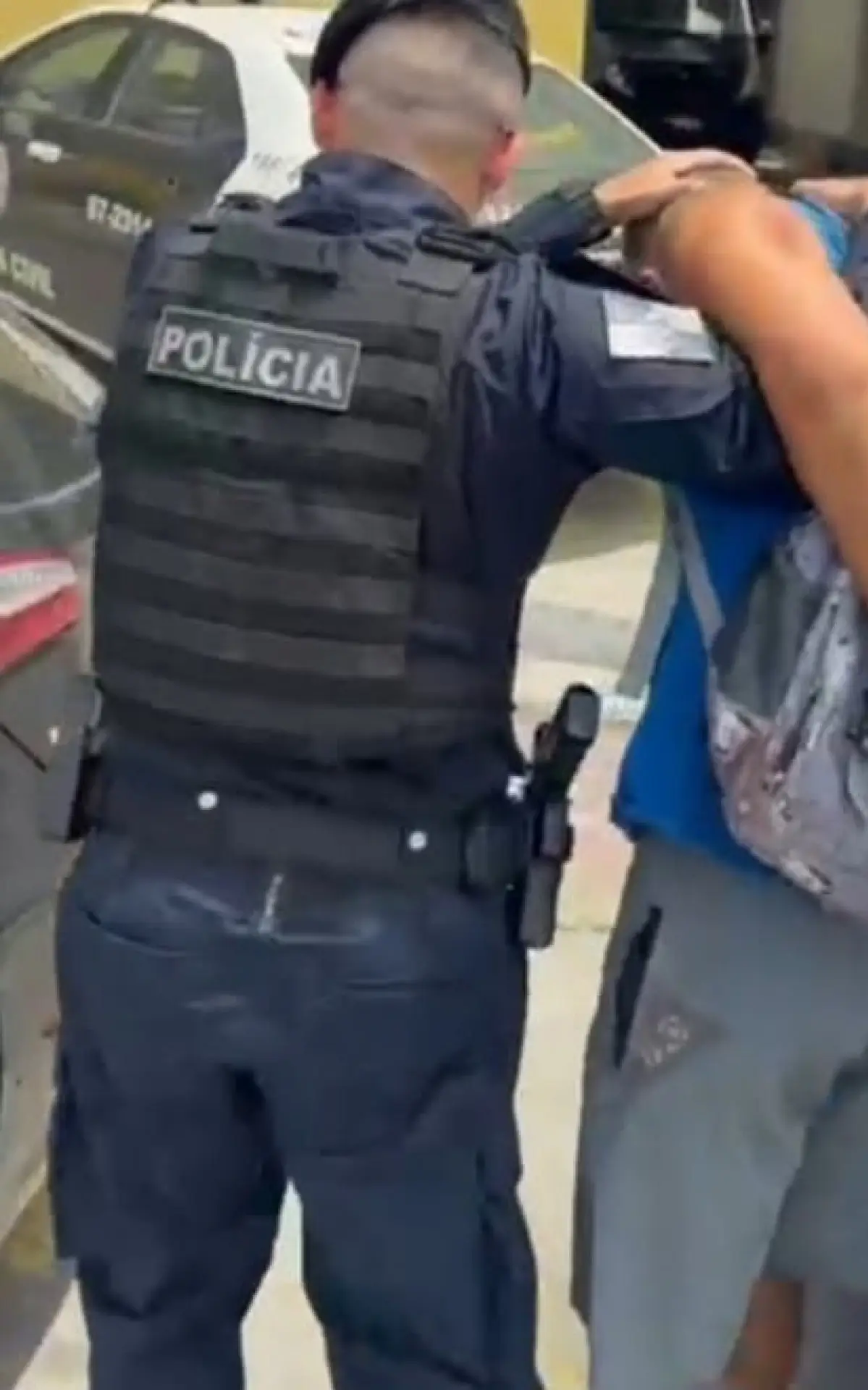 Policiais com Luciano algemado sendo levado à 166ª DP