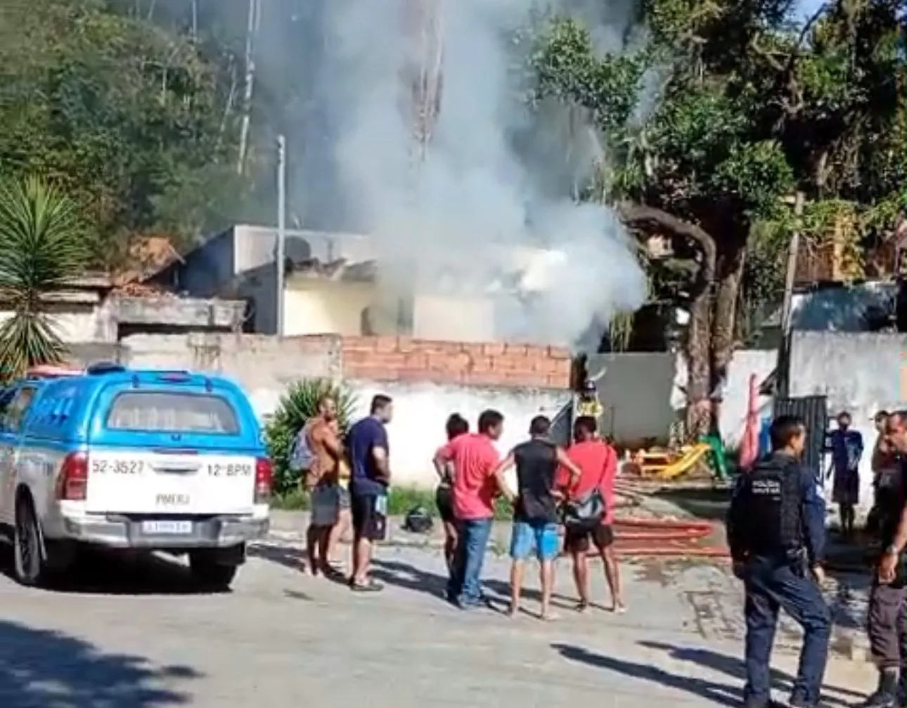 Militares, com ajuda de vizinhos, combatem o fogo no imóvel