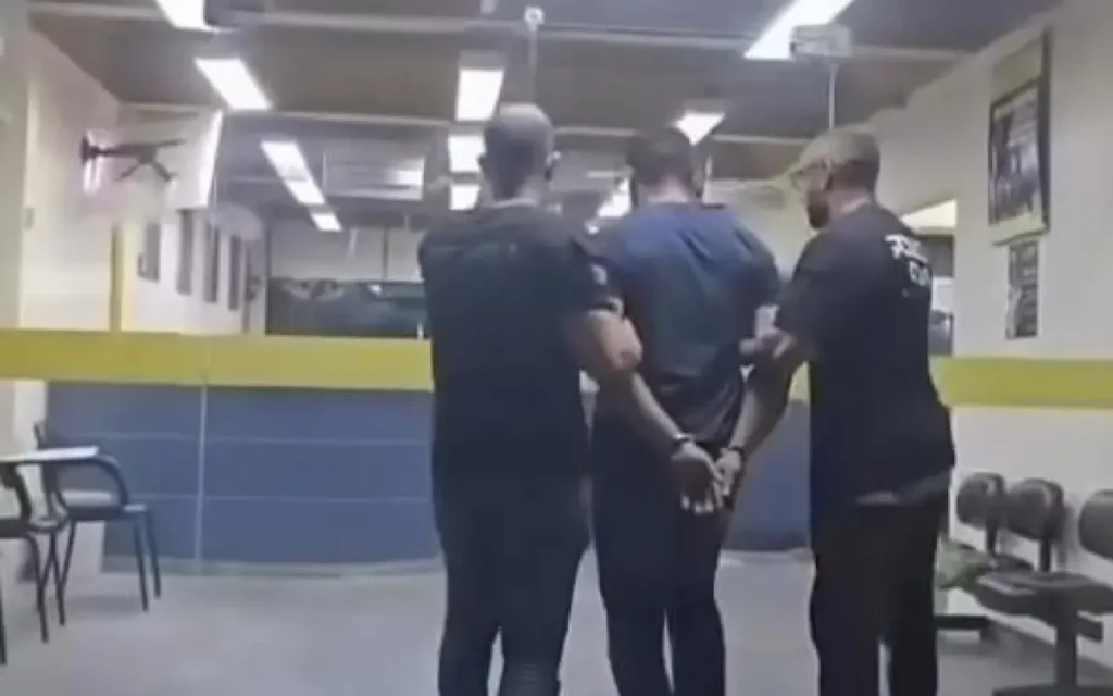 Chegada do acusado na 50ª DP por policiais civis