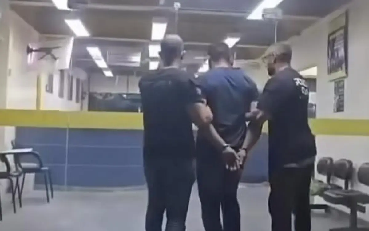 Chegada do acusado na 50ª DP por policiais civis