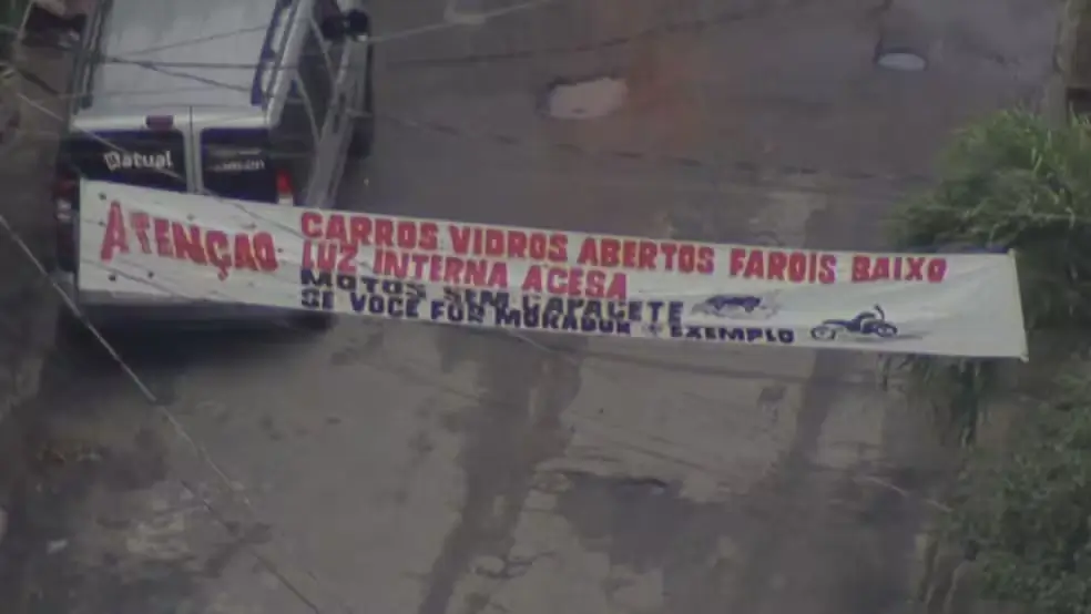Faixa para alertar moradores em um dos acesso à Comunidade Jardim Novo