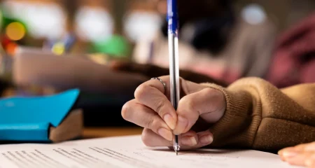Caneta escrevendo no caderno
